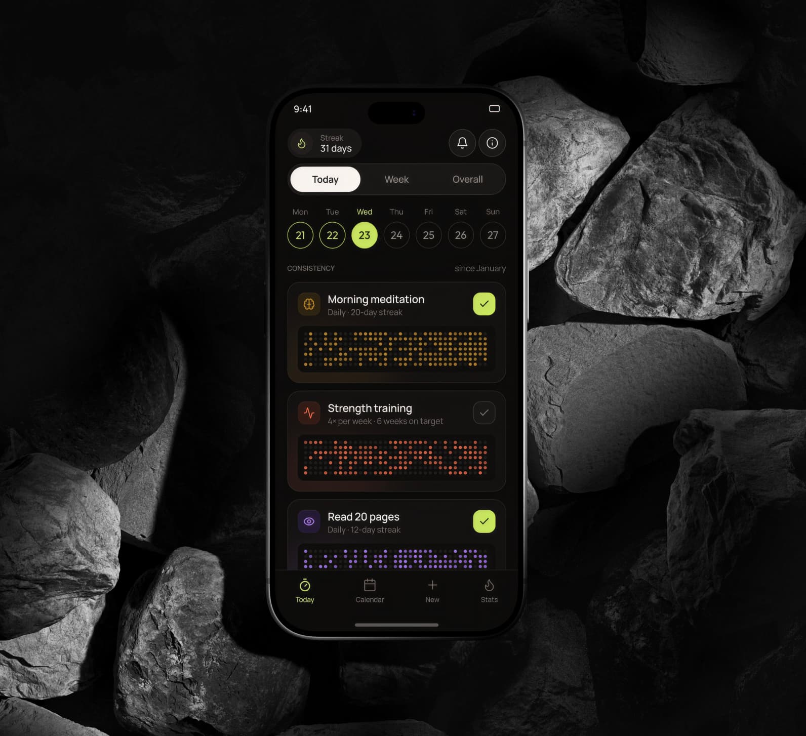 Habit Tracker app on an iPhone resting on dark rocks